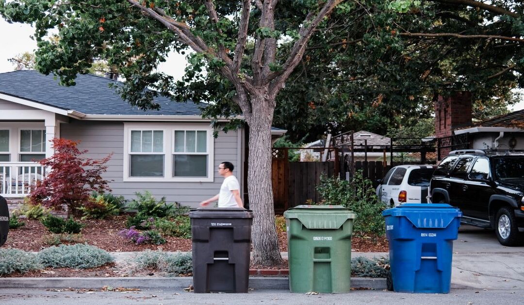 trash cans sitting in front of house